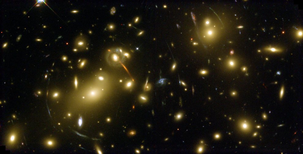 Abell 2218 cluster of galaxies in Draco @ 2 billion lys. Mass produces gravitational lensing (arc-shaped features) of objects 5 to 10 times farther than cluster - HST_hs-2000-07-b-full_990w